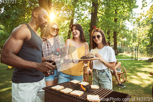 Image of Happy friends are having beer and barbecue party at sunny day