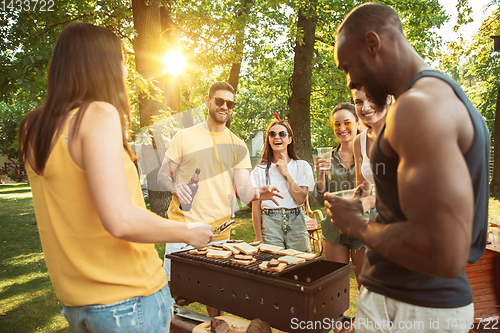 Image of Happy friends are having beer and barbecue party at sunny day