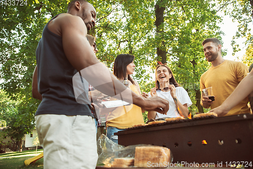 Image of Happy friends are having beer and barbecue party at sunny day