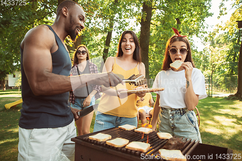 Image of Happy friends are having beer and barbecue party at sunny day