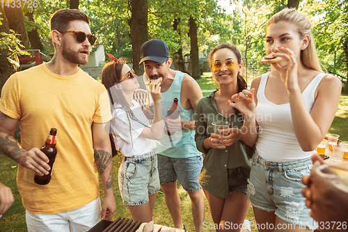 Image of Happy friends are having beer and barbecue party at sunny day