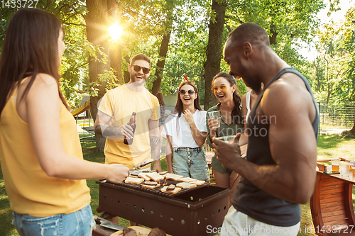 Image of Happy friends are having beer and barbecue party at sunny day