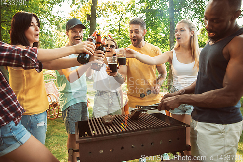 Image of Happy friends are having beer and barbecue party at sunny day