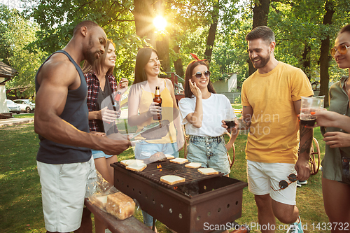 Image of Happy friends are having beer and barbecue party at sunny day