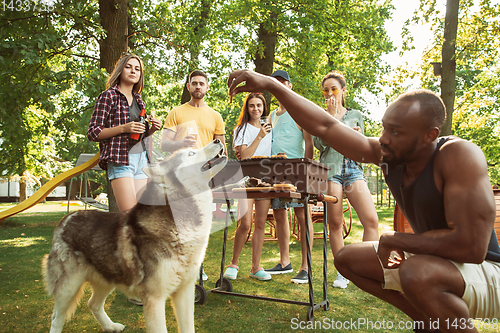 Image of Happy friends are having beer and barbecue party at sunny day