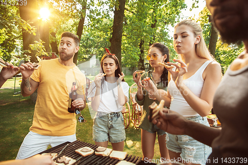 Image of Happy friends are having beer and barbecue party at sunny day