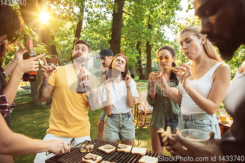 Image of Happy friends are having beer and barbecue party at sunny day