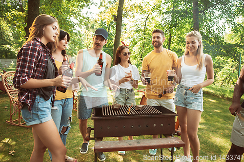 Image of Happy friends are having beer and barbecue party at sunny day