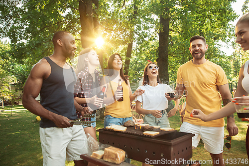 Image of Happy friends are having beer and barbecue party at sunny day