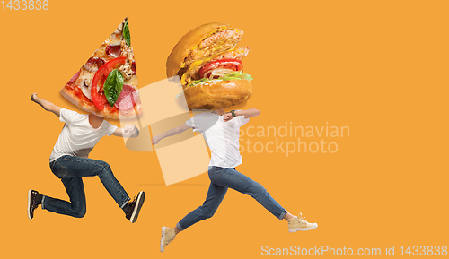 Image of Fast food concept. Young people running on orange background