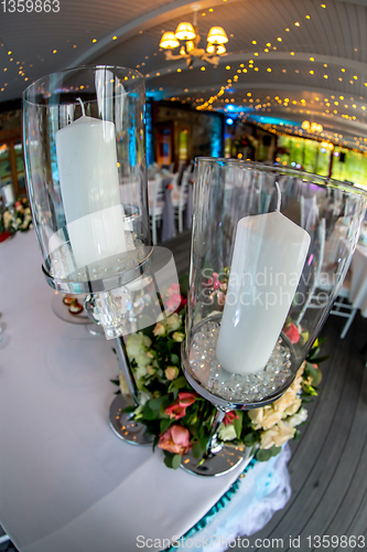 Image of Candles in candlestick and flowers on wedding table