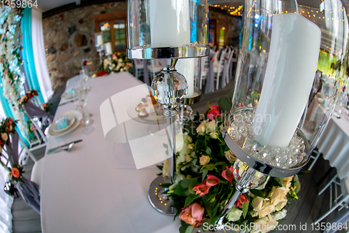 Image of Candles in candlestick and flowers on wedding table