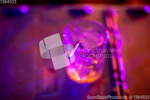 Image of Glass of cocktail in abstract lights