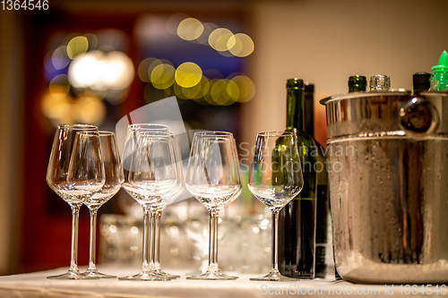 Image of Wine glasses, bottles and ice bucket on table