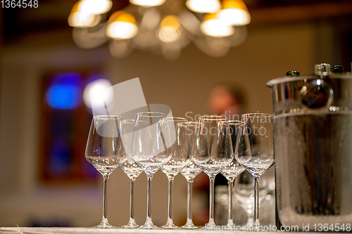 Image of Wine glasses, bottles and ice bucket on table