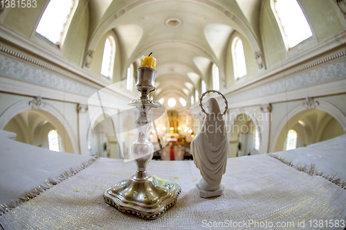 Image of Statue of Virgin Mary and candlestick in church