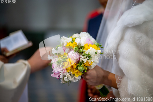 Image of Bouquet of flowers in the hand of the bride during the marriage 
