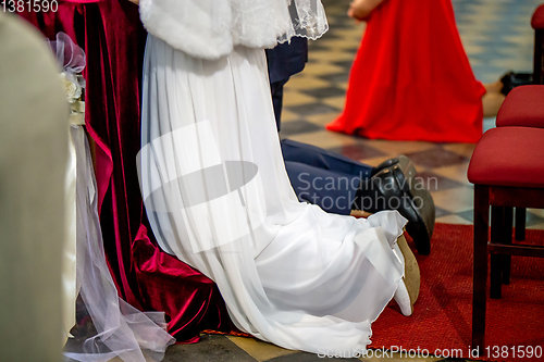 Image of Bride and groom during wedding ceremony in church.