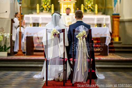 Image of Bride and groom during wedding ceremony in church.