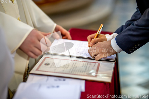 Image of Groom signs document on registration of marriage