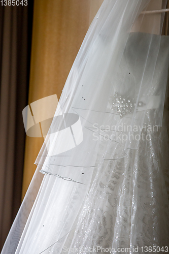 Image of Bridal dress hanging at wooden closet