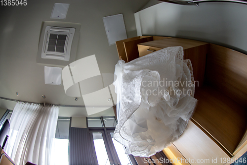 Image of Bridal dress hanging at wooden closet