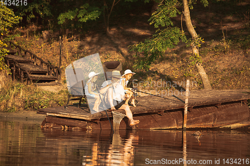 Image of Cute little girls and their granddad are on fishing at the lake or river