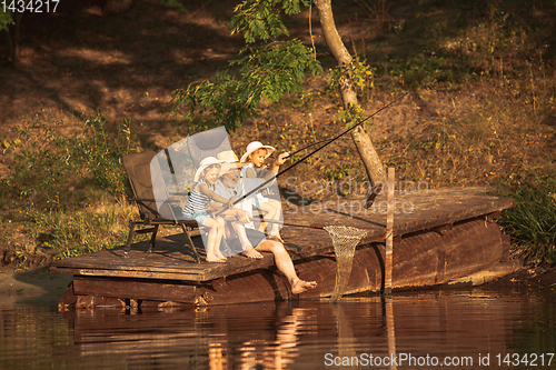 Image of Cute little girls and their granddad are on fishing at the lake or river