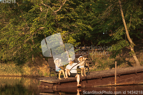 Image of Cute little girls and their granddad are on fishing at the lake or river