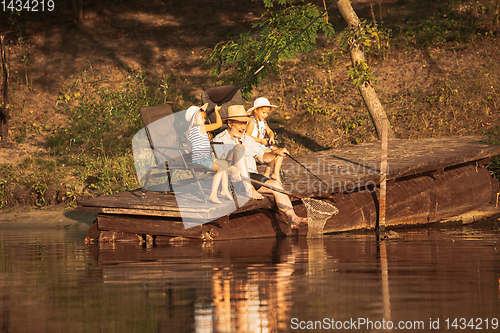 Image of Cute little girls and their granddad are on fishing at the lake or river