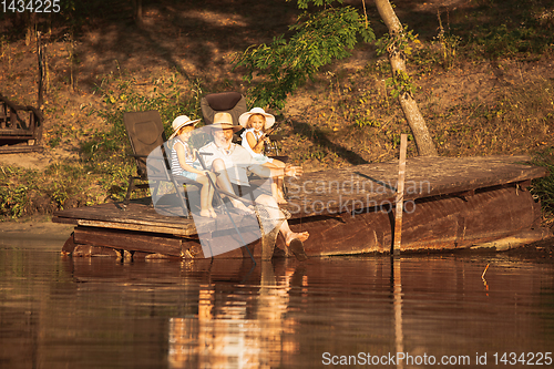 Image of Cute little girls and their granddad are on fishing at the lake or river