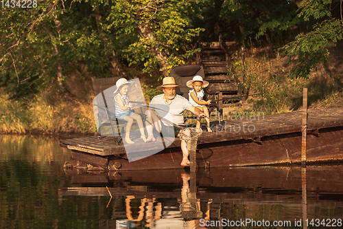 Image of Cute little girls and their granddad are on fishing at the lake or river