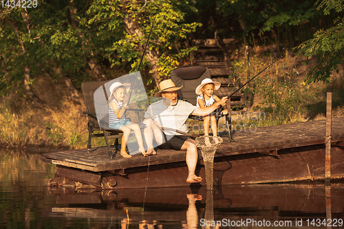 Image of Cute little girls and their granddad are on fishing at the lake or river