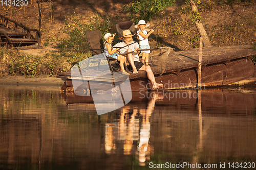 Image of Cute little girls and their granddad are on fishing at the lake or river