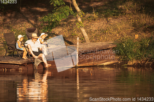 Image of Cute little girls and their granddad are on fishing at the lake or river