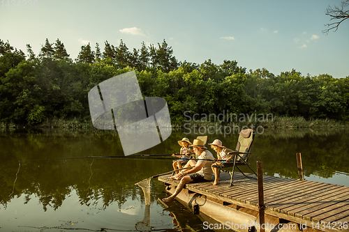 Image of Cute little girls and their granddad are on fishing at the lake or river