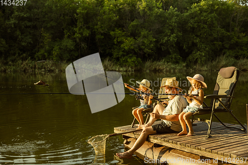 Image of Cute little girls and their granddad are on fishing at the lake or river