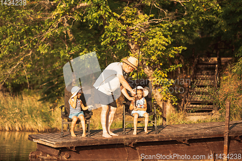 Image of Cute little girls and their granddad are on fishing at the lake or river