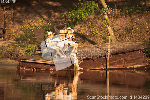 Image of Cute little girls and their granddad are on fishing at the lake or river