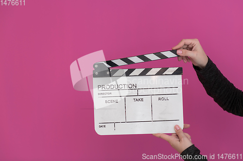 Image of movie clapper on pink background