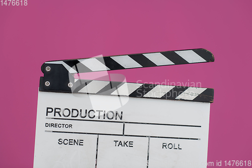 Image of movie clapper on pink background