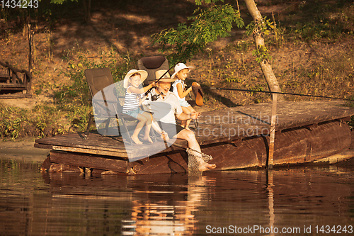 Image of Cute little girls and their granddad are on fishing at the lake or river