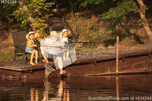 Image of Cute little girls and their granddad are on fishing at the lake or river