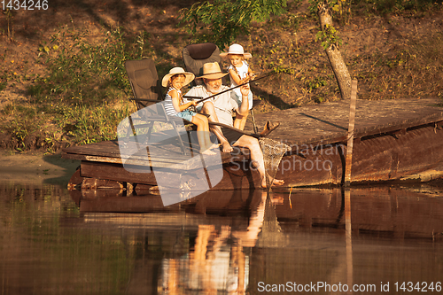 Image of Cute little girls and their granddad are on fishing at the lake or river