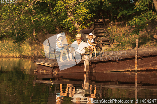 Image of Cute little girls and their granddad are on fishing at the lake or river