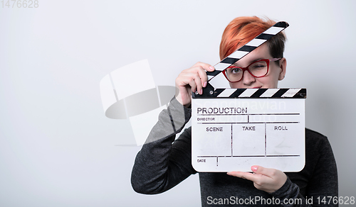 Image of redhead woman holding movie  clapper on white background