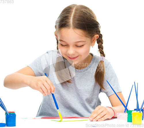 Image of Little girl is painting with gouache