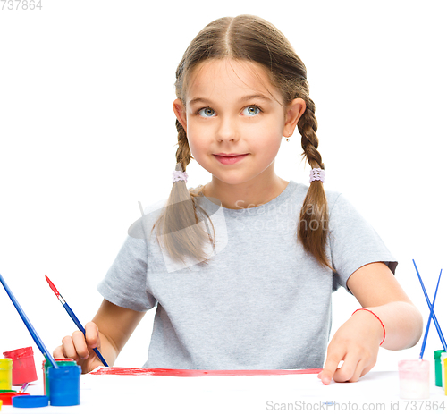 Image of Little girl is painting with gouache
