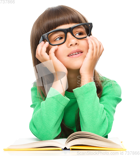 Image of Young girl is daydreaming while reading book