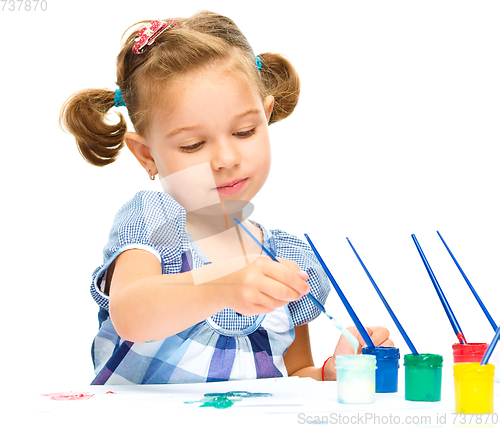 Image of Little girl is painting with gouache